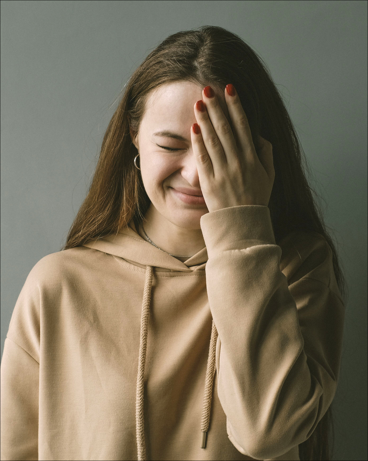 Girl with hand over part of face as if embarrassed.